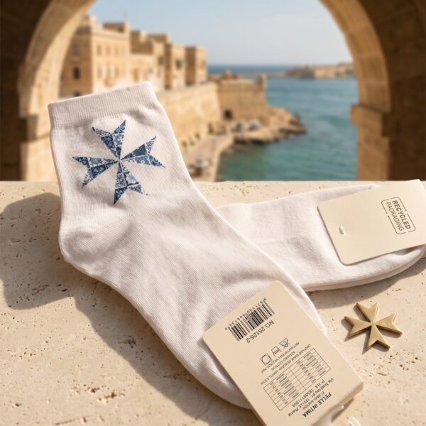 Weiße Socken mit blauem Malteserkreuz auf einer Mauer über dem Hafen