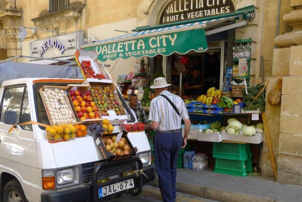 Obst- und Gemüsestand mit Verkaufswagen in einer Gasse in Valletta
