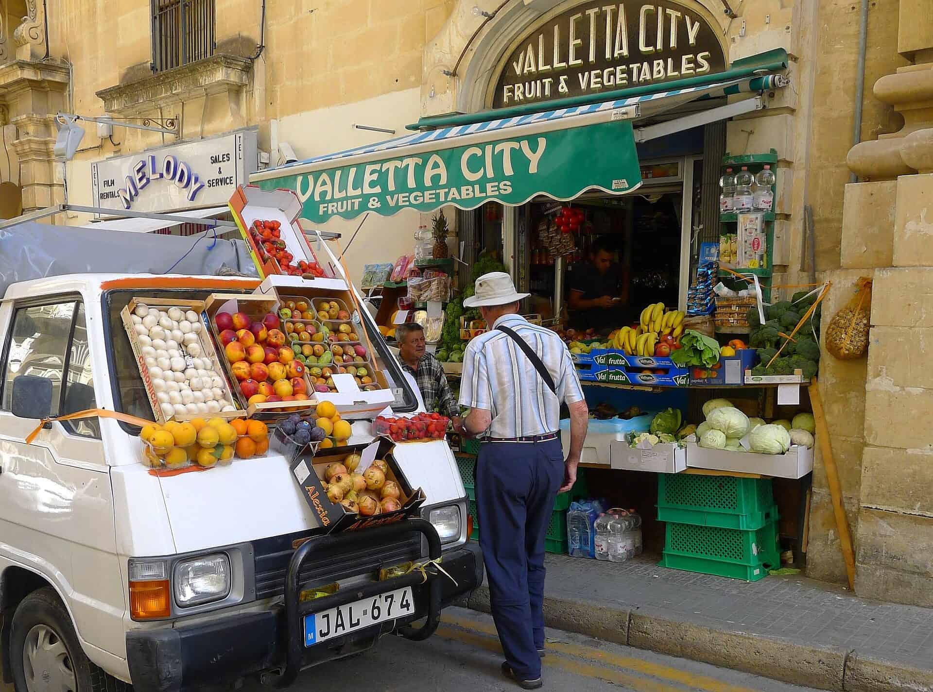 Obst- und Gemüsestand mit Verkaufswagen in einer Gasse in Valletta