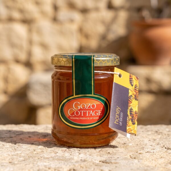 Reiner Gozo Honig von Gozo Cottage im Glas mit Bienen-Anhänger auf Steinmauer