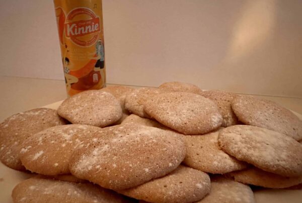 Stapel selbstgebackener Kinnie Cookies mit Puderzucker neben einer Kinnie Dose
