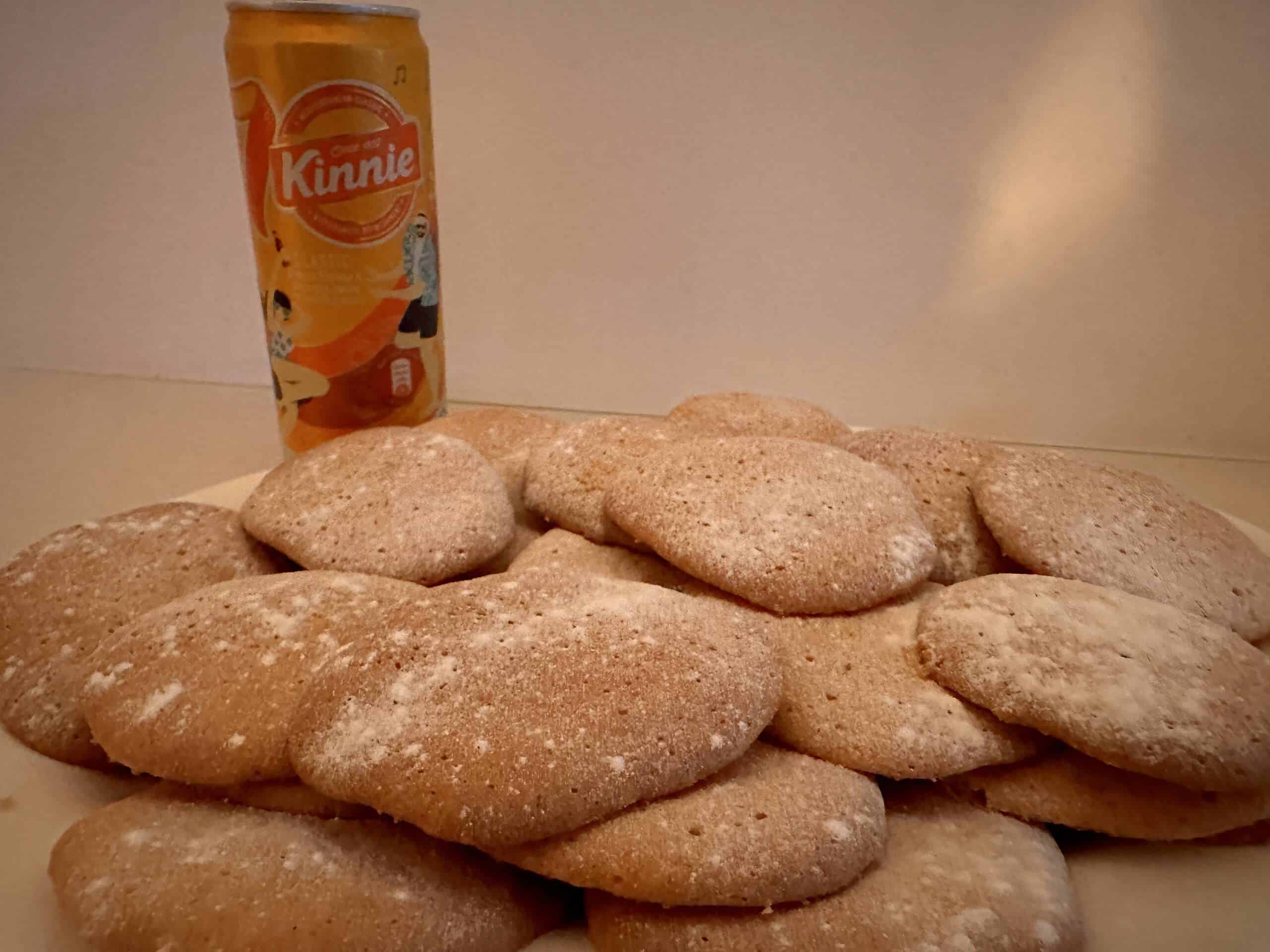Stapel selbstgebackener Kinnie Cookies mit Puderzucker neben einer Kinnie Dose