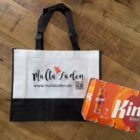 Malta Laden Einkaufstasche mit Logo neben einem Kinnie 6er-Pack in Dosen