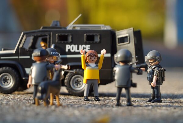 Playmobil-Polizeifiguren mit Einsatzwagen in einer nachgestellten Spielszene