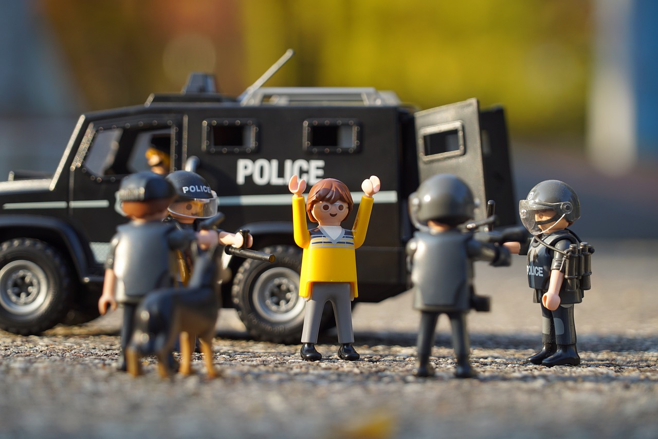 Playmobil-Polizeifiguren mit Einsatzwagen in einer nachgestellten Spielszene